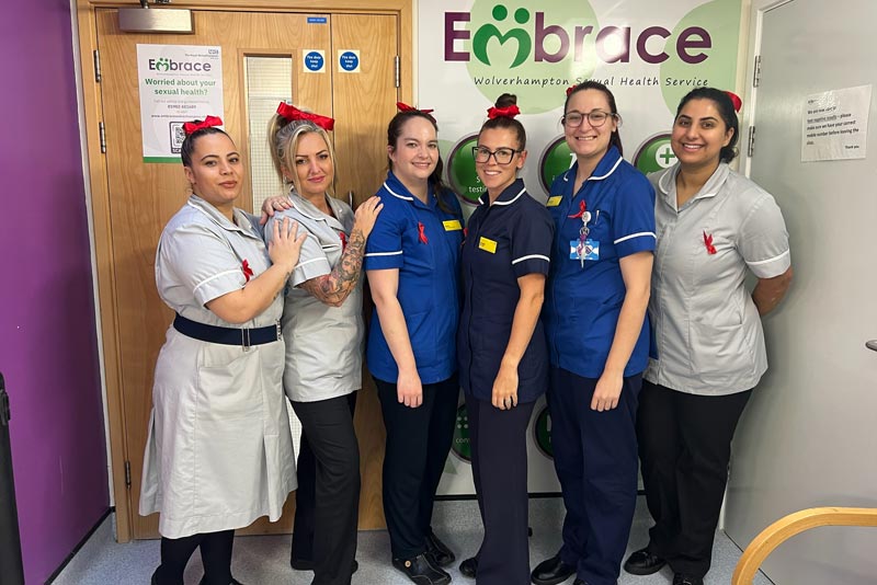 Embrace staff wearing red ribbons